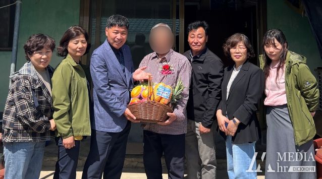 학교면 직원들이 독거 어르신에게 과일바구니를 전달하고 있다