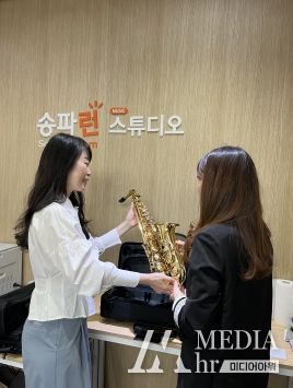 ‘송파런 뮤직 스튜디오’에서 악기(가야금과 클라리넷)를 빌리고 있는 주민들 모습
