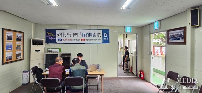 화순전통시장상인회에서 운영된 마을세무사 이세형(사진 뒤쪽)과 군민(사진 앞쪽)과의 상담 장면을 촬영한 사진