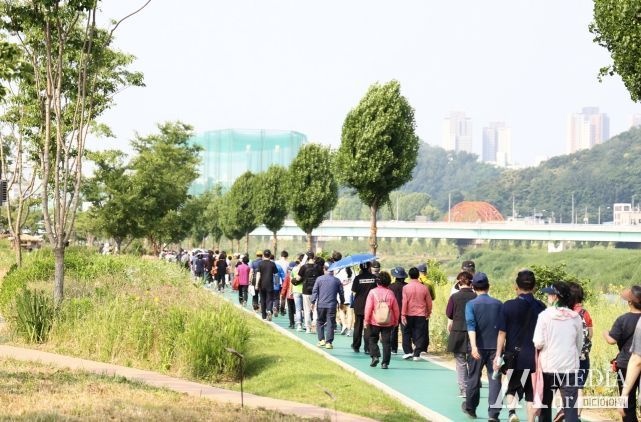 지난 제133회 안양천사랑 가족건강 오프라인 건강행사에서 주민들이 안양천을 따라 걷고 있다.